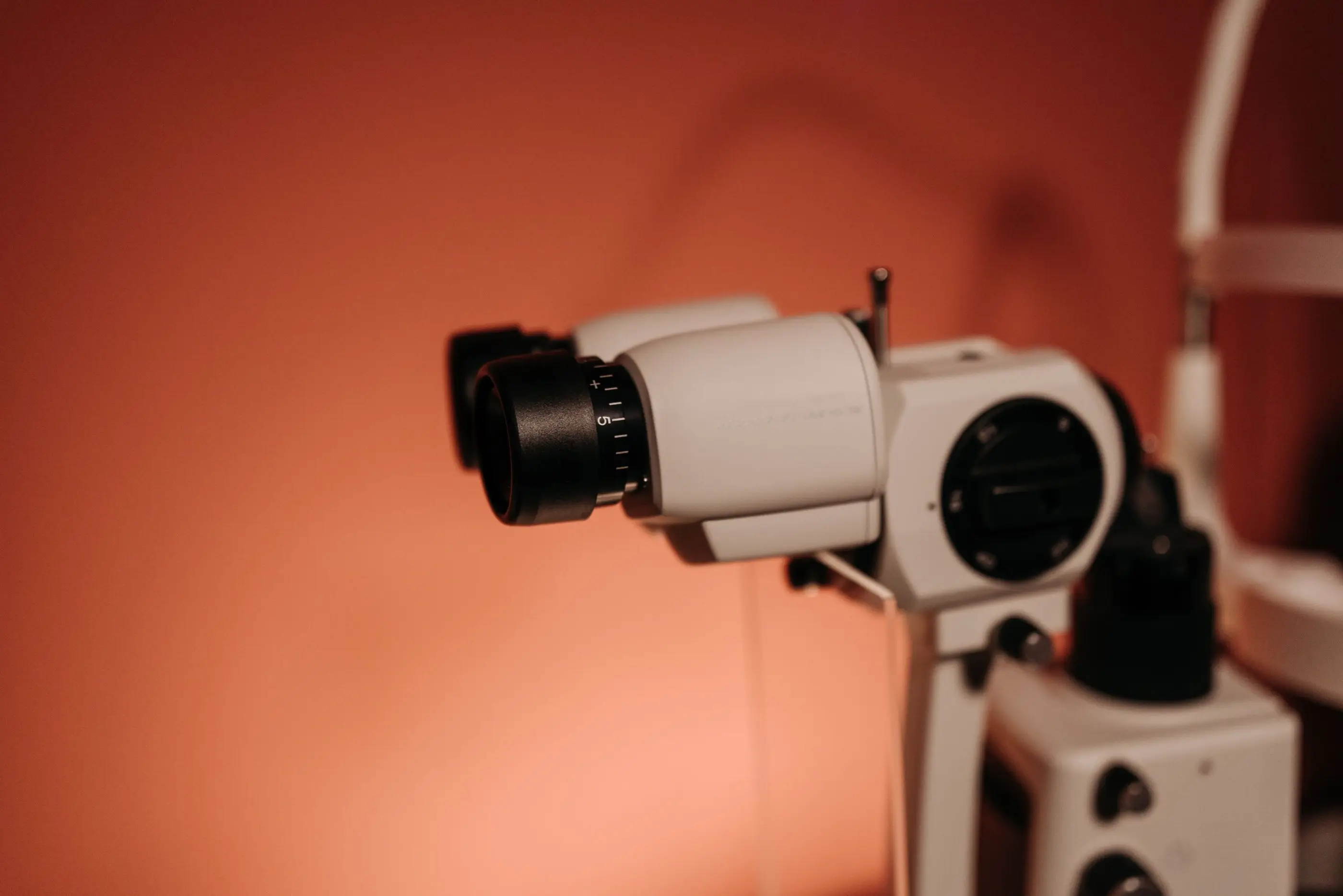 A slit lamp microscope against a warm wall